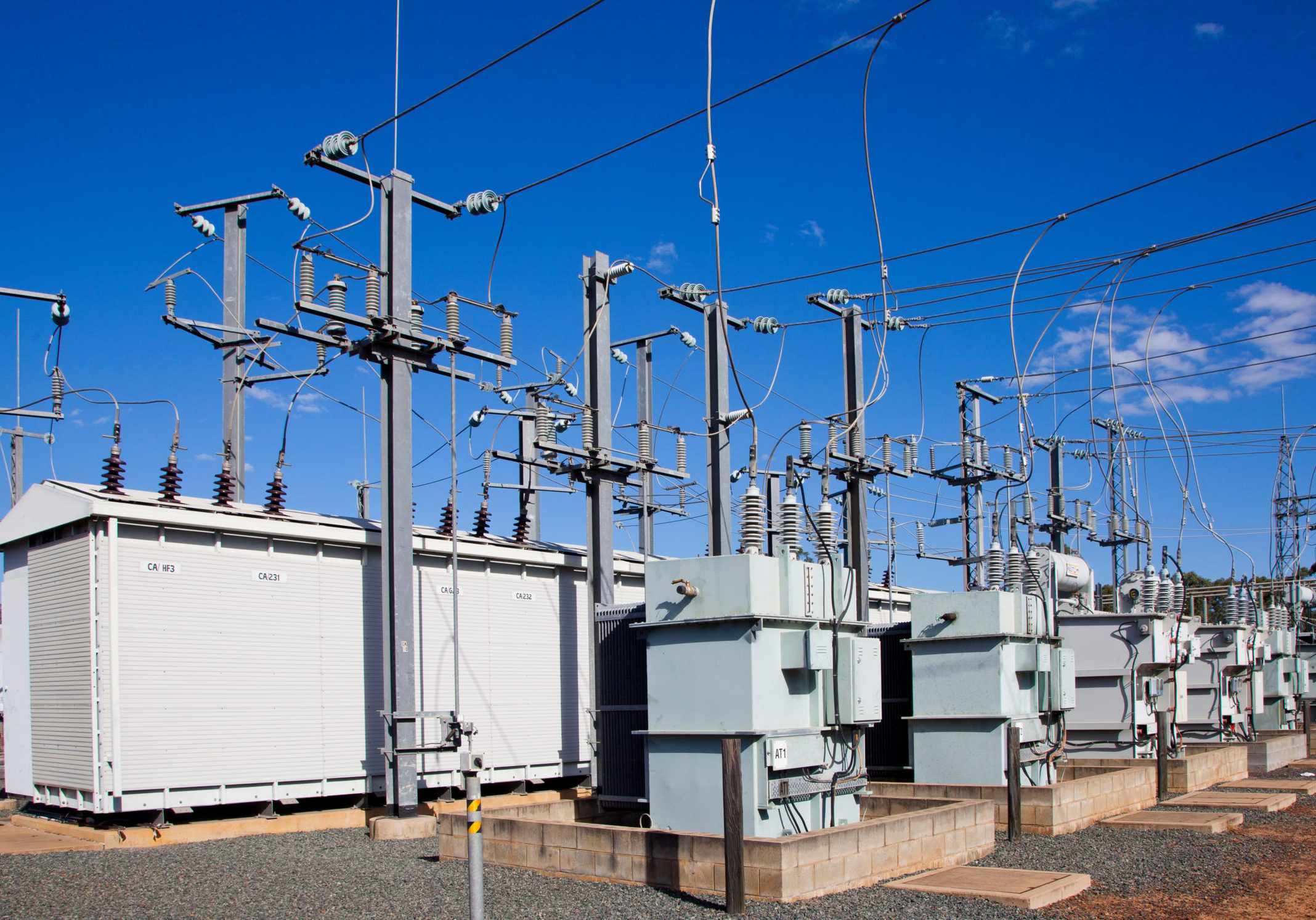 Electrical substations, Pylons and wires distribute power through high-voltage transmission lines. Blue Sky. Queensland, Australia.